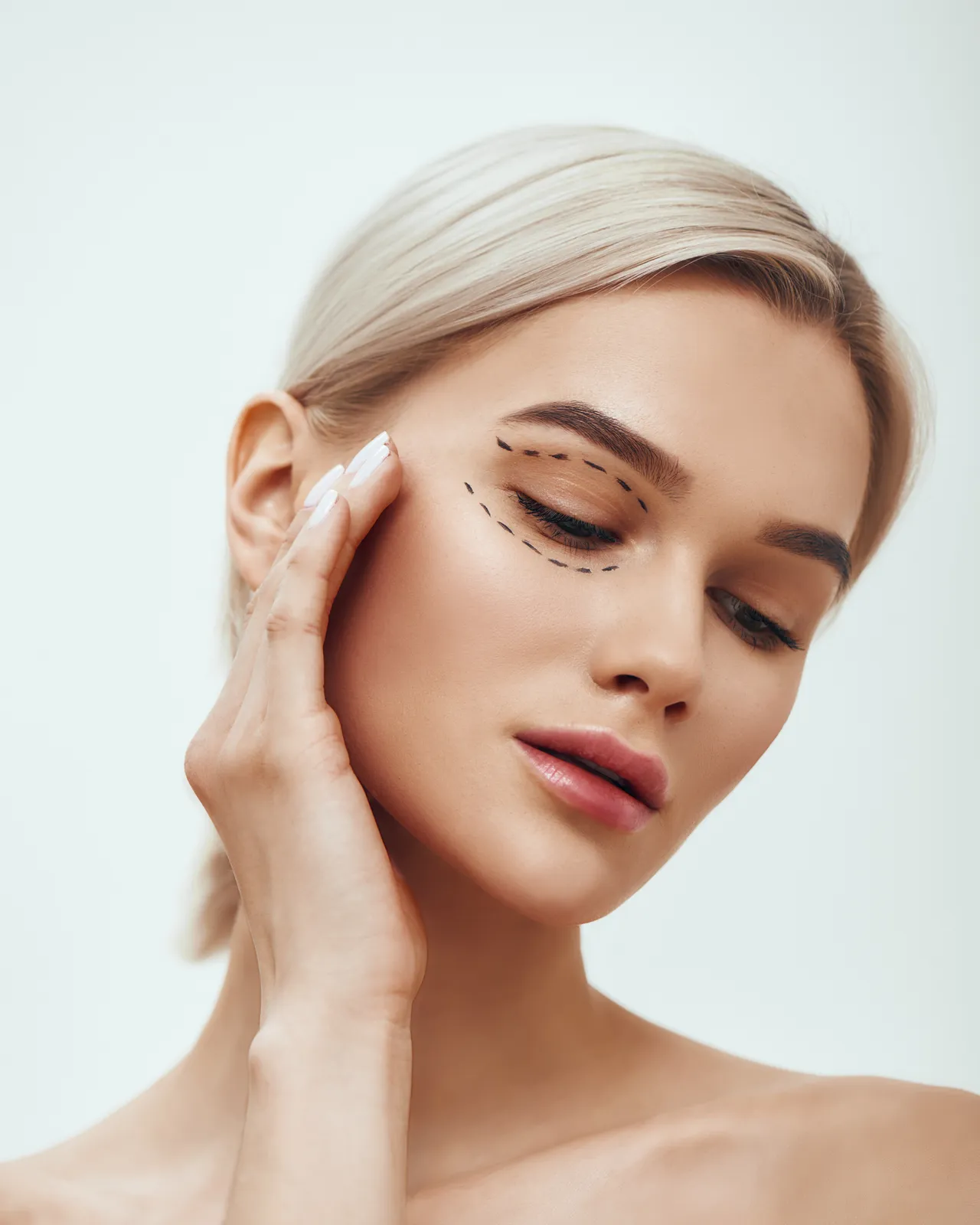Woman with closed eyes touching the skin under her eye